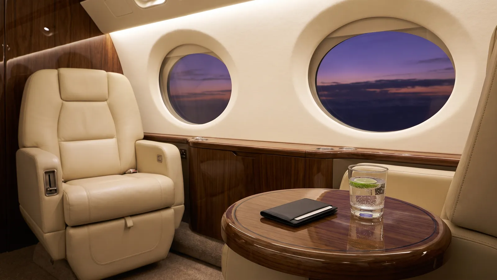 A private jet cabin at dusk, a leather card wallet resting on a walnut table